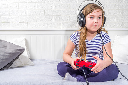 Llittle child kid girl playing video games, a Photo by Rimma