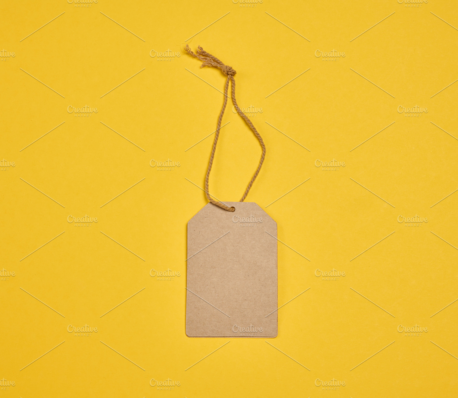 A blank craft rectangular tag with a string, centered on a yello, a Holiday Photo by ndanko