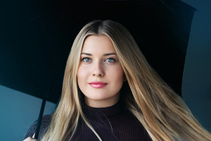 Young blonde woman with blue eyes holding a black umbrella, posi, a Person Photo by Studio ANNA