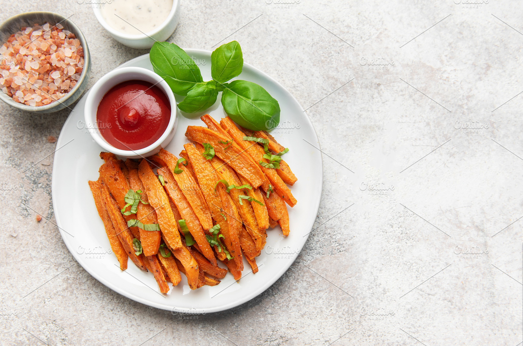 Sweet potato fries with ketchup and basil garnish, a Food & Drink Photo by Olena Rudo