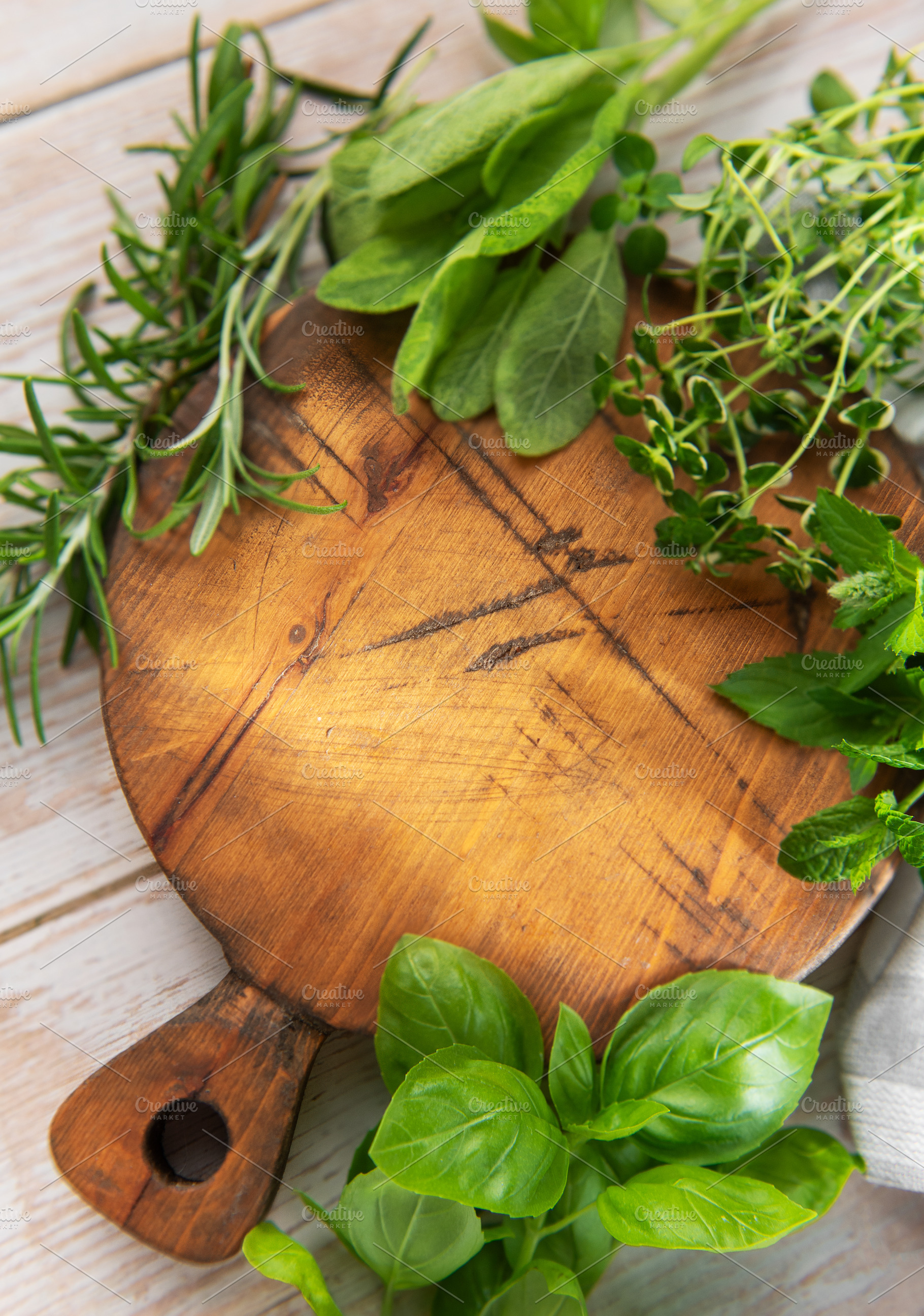 Fresh cooking herbs on rustic wooden cutting board, a Food & Drink Photo by Olena Rudo
