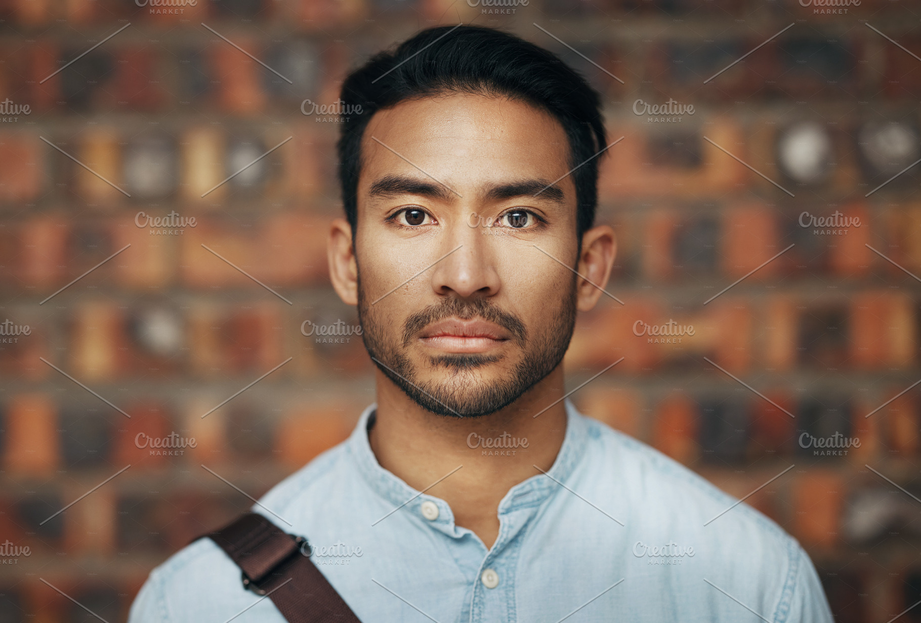 Serious, confidence and portrait of a businessman in the office standing by a brick wall. Pride, professional and face of an Indian corporate male employee or expert with success in modern workplace., a Photo by Peopleimages.com