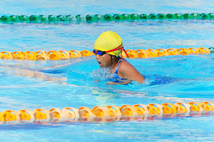 Swimmer child swims breaststroke swimming style in a race swimmi