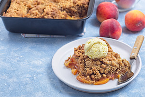 Peach Crisp or cobbler on plate with scoop of vanilla ice cream, horizontal, co, a Food & Drink Photo by iuliia_n