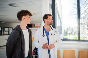 Doctor walking teenage patient out, a Person Photo by HalfPoint