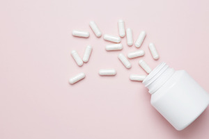 Concept of healthcare and medicine. White bottle container with medication caps, a Photo by matucha