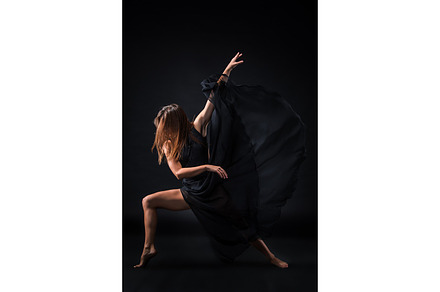 Young beautiful dancer in beige dress dancing on black background stock photo, a Sports & Recreation Photo by Volodymyr Melnyk