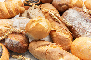 Variety of fresh baked bread, pastry, and wheat ears, a Food & Drink Photo by Olena Rudo