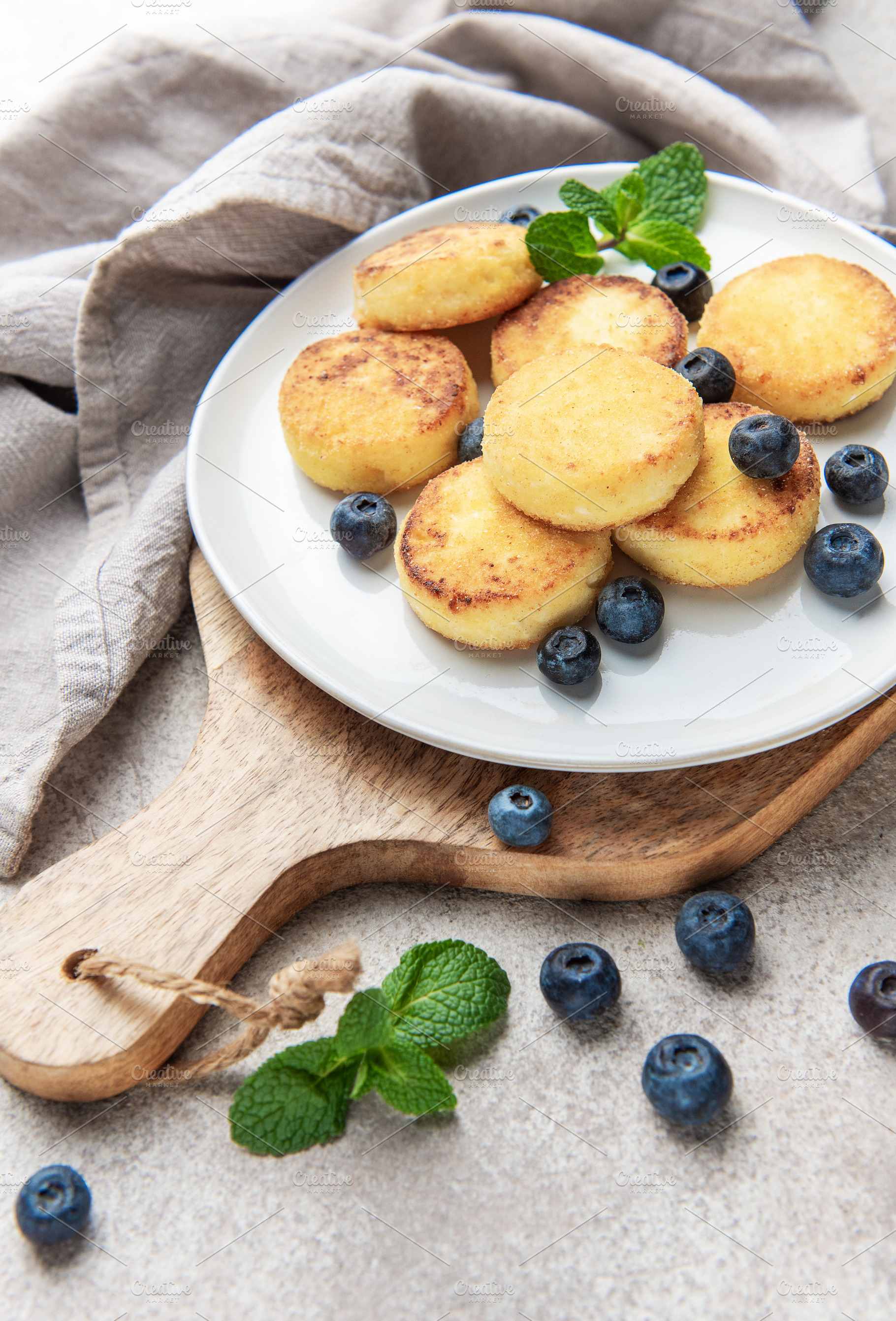 Syrniki pancakes with blueberries and mint for breakfast, a Food & Drink Photo by Olena Rudo