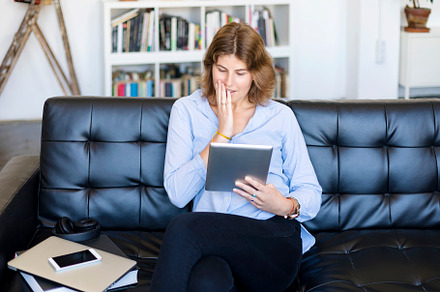 Beautiful young woman using tablet sitting on sofa at home at living room., a Person Photo by 2Design