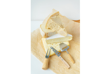 Different types of cheese lie on top, a Food & Drink Photo by Artsaba Family