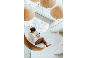 A woman sits in a modern lounge, an Architecture Photo by Sergey Kotenev