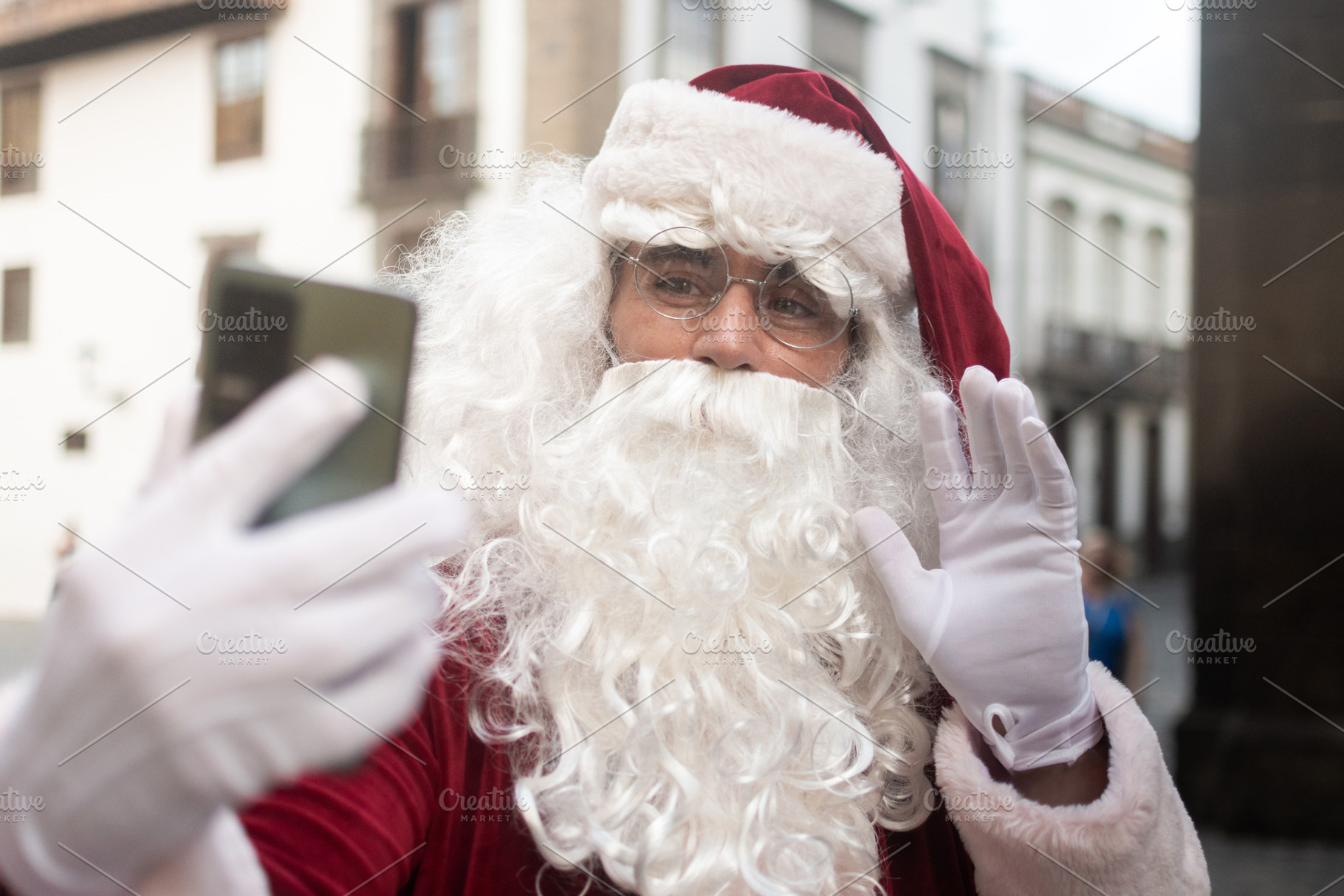 Santa Claus making video call and waving with smartphone, a Holiday Photo by etorres69