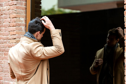 Portrait of stylish young man with coat standing outdoors lookin, a Person Photo by RF Images
