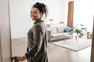 Cheerful Black Female Opening Entry Door Entering Apartment, a Photo by Prostock-Studio