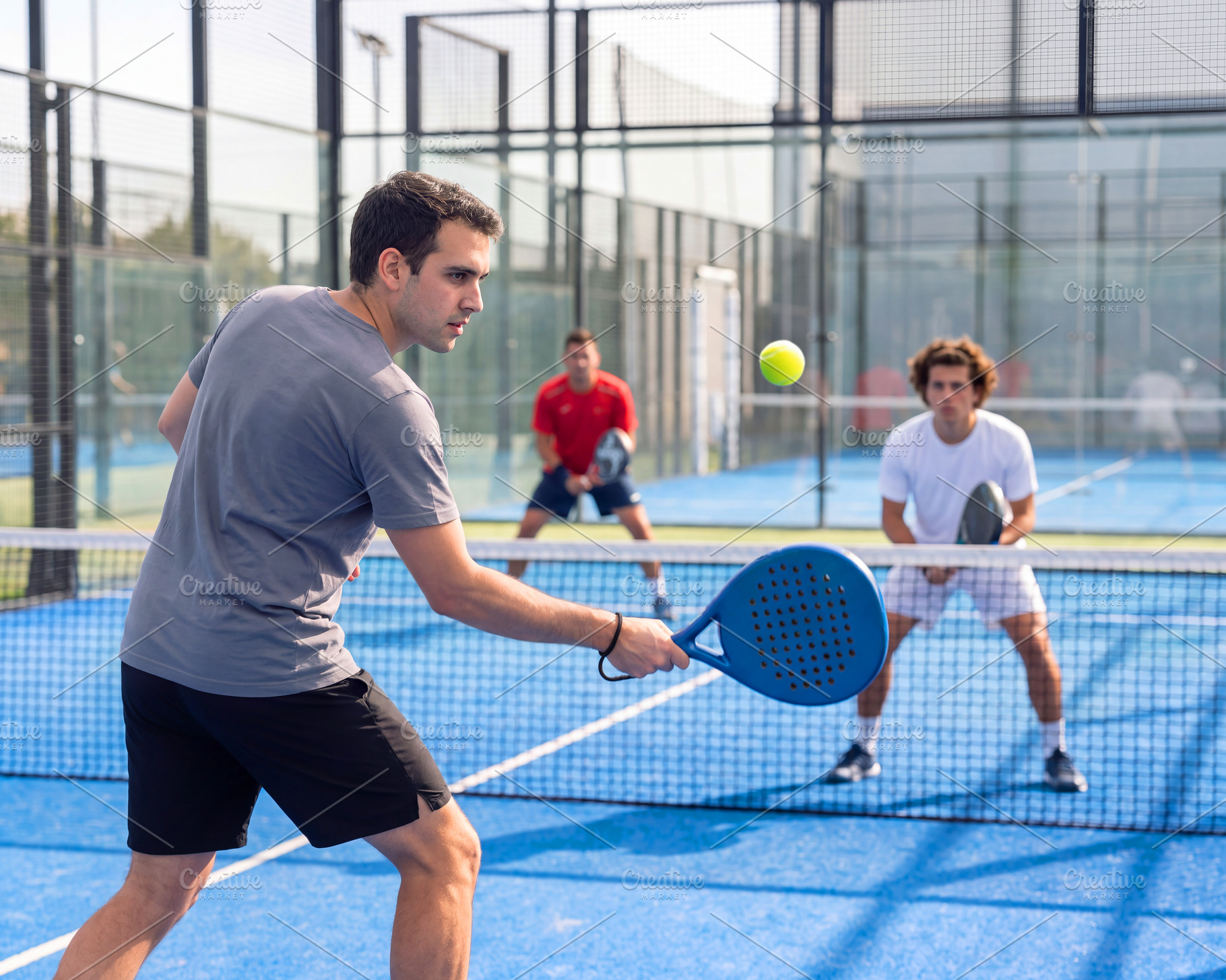 Action shot of young male padel players in full match on outdoor, a Sports & Recreation Photo by Volff