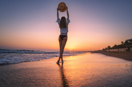 Beautiful woman with straw hat is standing in sea with waves, a Person Photo by den-belitsky