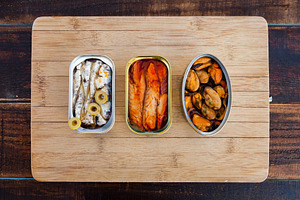 Three different opened cans of preserved, a Food & Drink Photo by José Manuel Gelpi