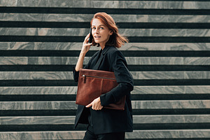 Smiling and busy female in black, a Business Photo by Artem Varnitsin