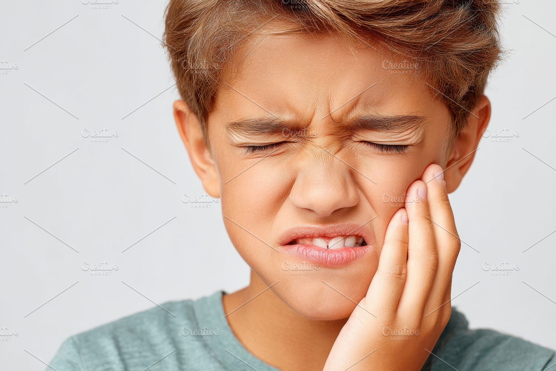 Young child making a disgusted face because of a toothache, a Health & Medical Photo by AlyaAnd