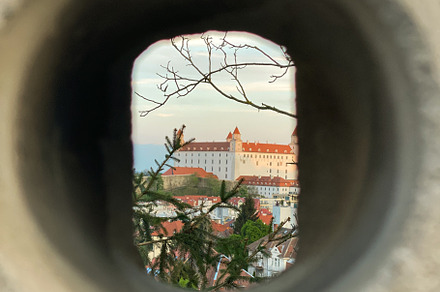 View of Bratislava Castle framed through a circular stone openin