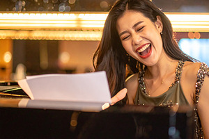 A beautiful singer playing piano at bar, a Person Photo by DanFLCreativo