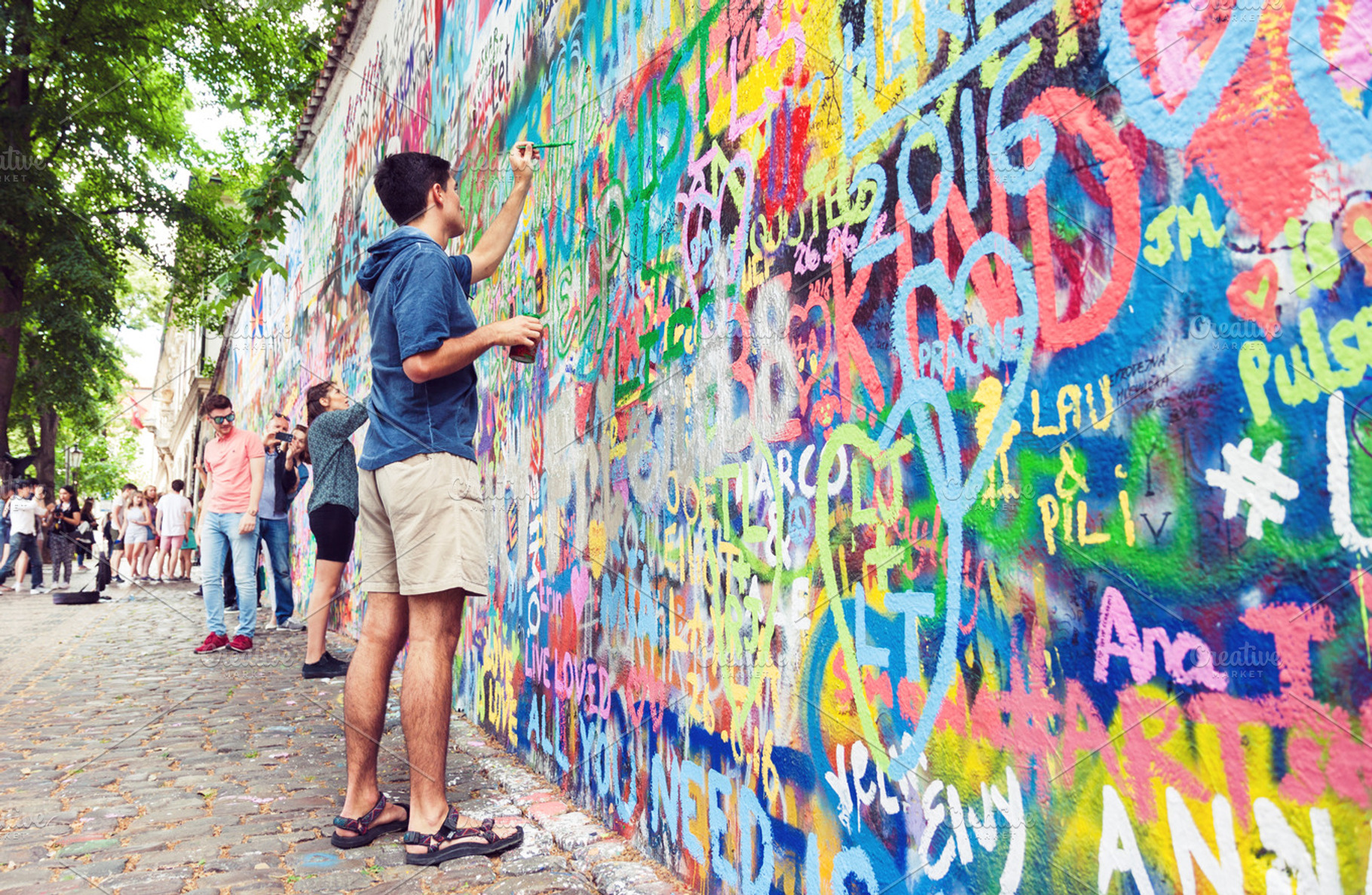 Young man painting grafitti wall, an Arts & Entertainment Photo by BOOCYS