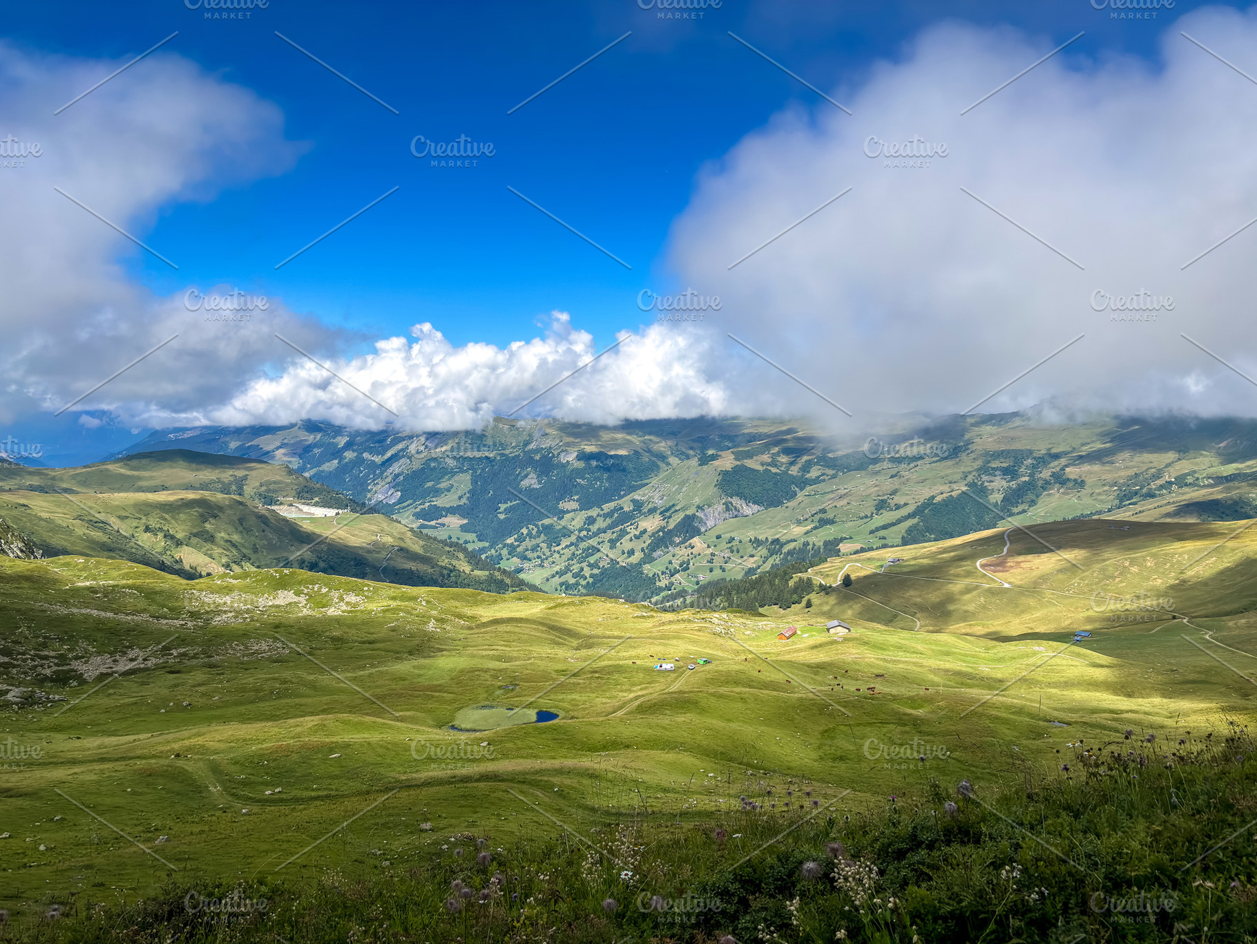 Mountain pastures and clouds above alpine valleys in Les Contami, a Nature Photo by GoodGoods
