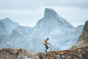 Man hiking in mountains traveling solo with backpack outdoor active vacations i