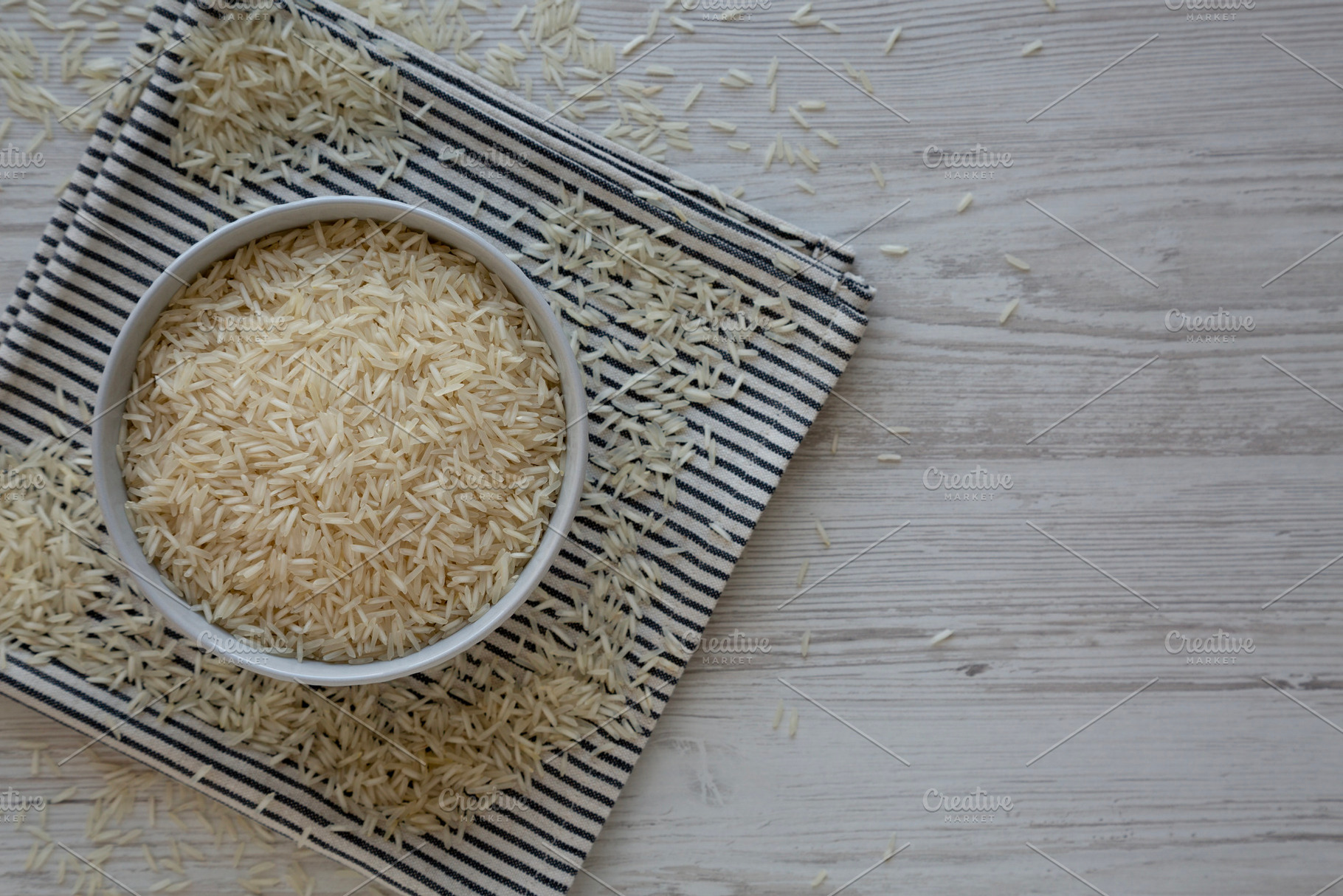 Uncooked White Organic Basmati Rice in a Bowl, top view. Space f, a Food & Drink Photo by LiudmylaChuhunova