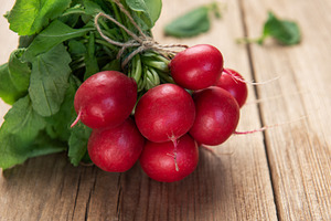 Fresh radishes bunch with green leaves on wood table, a Food & Drink Photo by Olena Rudo
