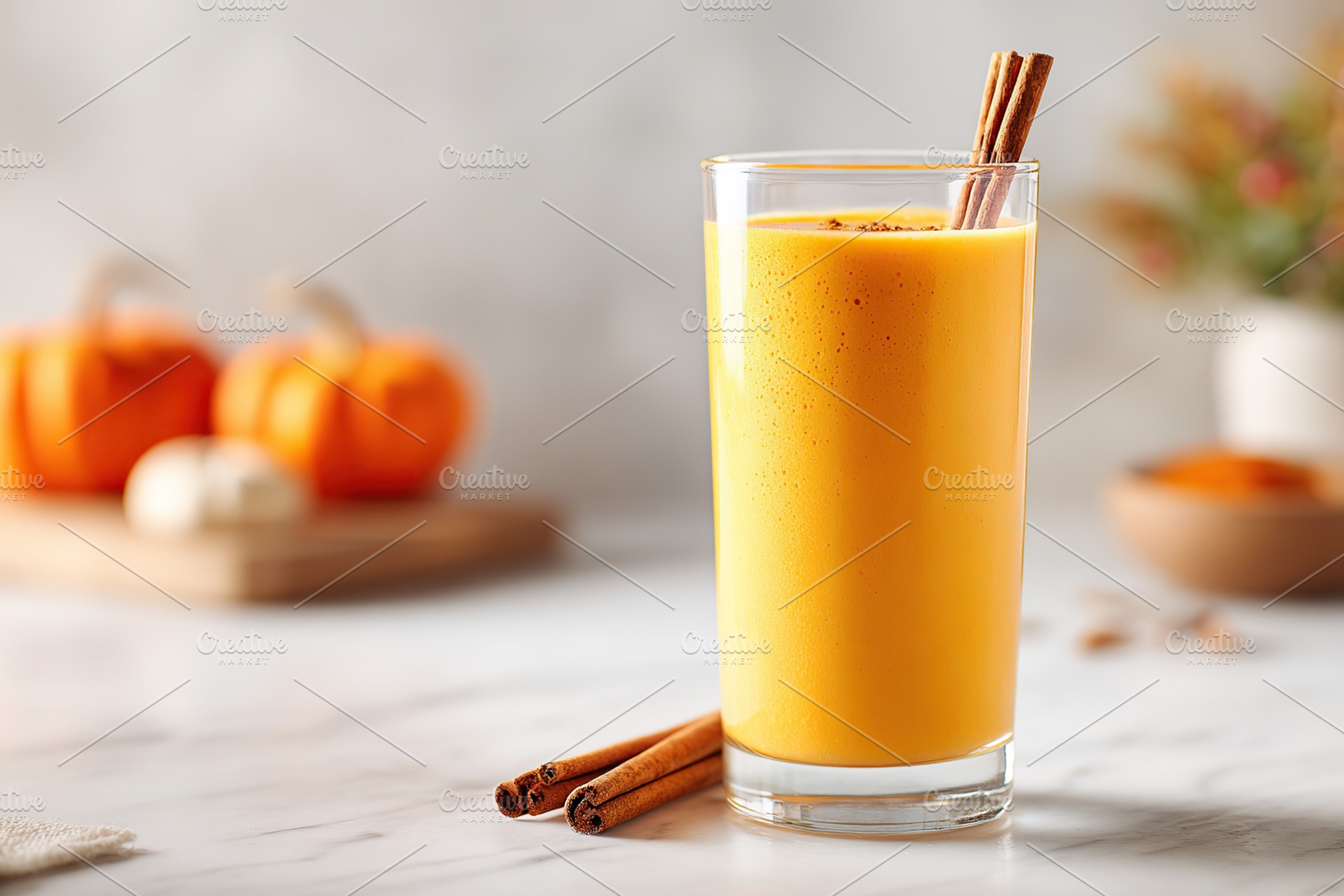 Creamy pumpkin smoothie served with cinnamon sticks on a marble countertop, a Photo by AlyaAnd