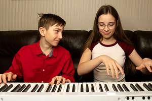 Boy and girl playing the piano, a School & Education Photo by Elena Vagengeim