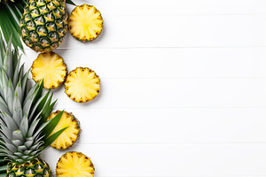 Ripe sliced pineapples on wooden background, a Food & Drink Photo by AlyaAnd