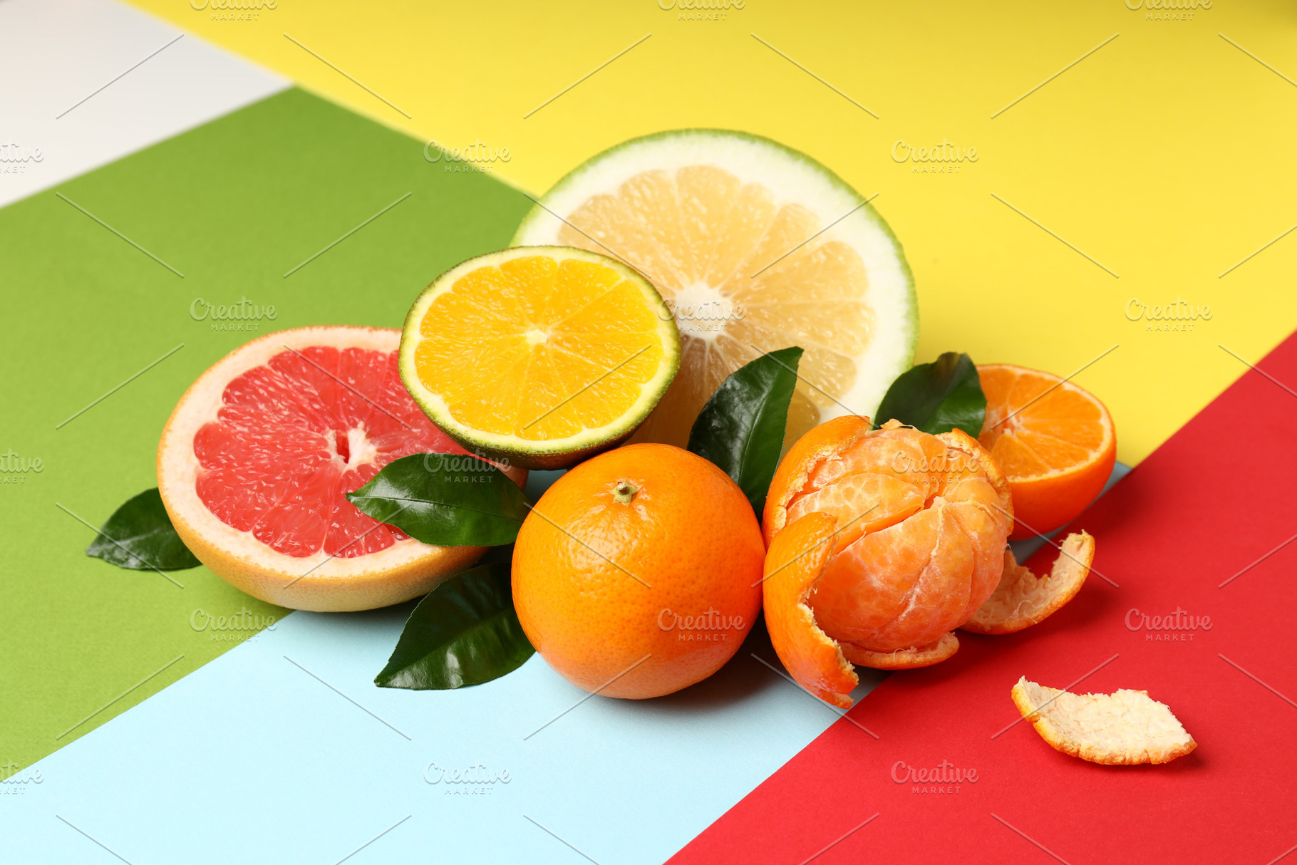 Citrus fruits with leaves on multicolored background, a Food & Drink Photo by AtlasStudio PRO