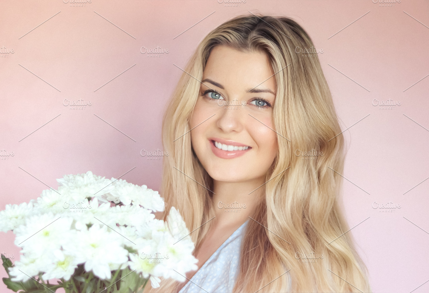 Holding white chrysanthemums, the smiling woman poses against a, a Person Photo by Studio ANNA