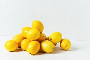 Heap of lemons on white table
