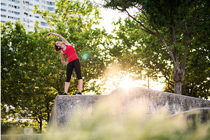 Young woman doing exercise outdoors, a Graphic by HalfPoint