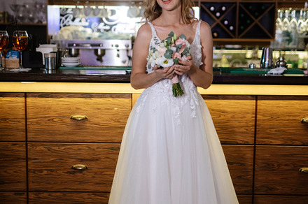 blonde bride in a bar near with a wedding bouquet, a Person Photo by Weddings, People, Travel