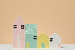 A row of stylized wooden houses of different sizes and colors on, a Business Photo by ndanko