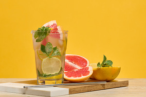 Glass with cocktail and grapefruit, lemon and orange slices. Yel, a Food & Drink Photo by ndanko
