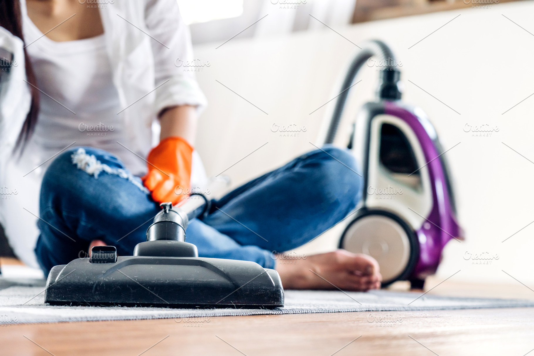 Young woman in protective gloves cleaning home with vacuum clean, a Person Photo by Art_Photo
