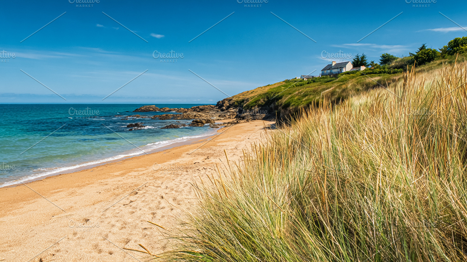 Coastal scene with golden sand beach, turquoise ocean water, roc, a Photo by Studio ANNA