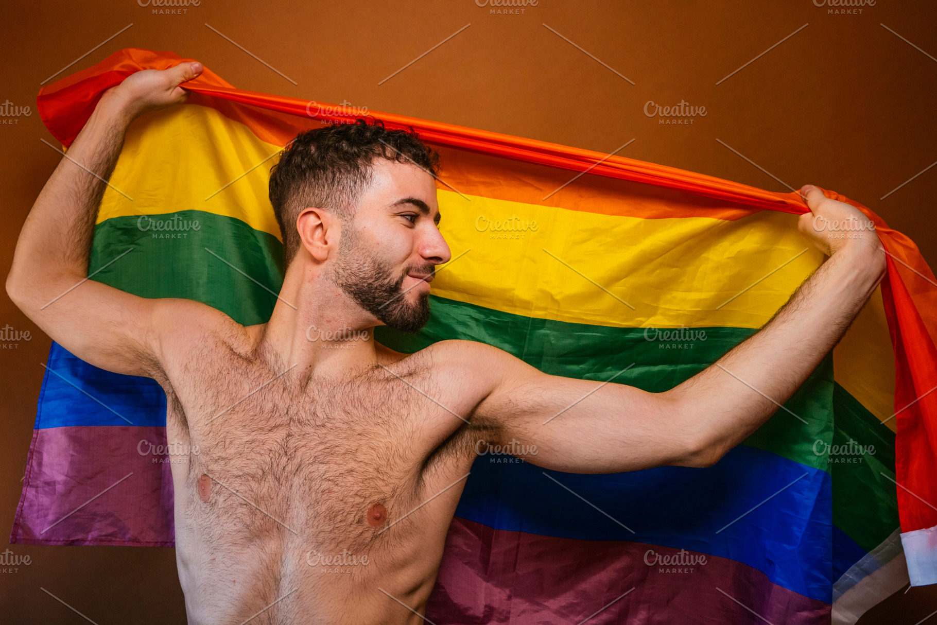 Man holding rainbow pride flag celebrating lgbtq+ identity, a Photo by karrastock