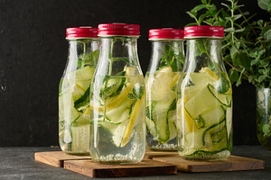 A row of glass bottles with red lids filled with refreshing deto, a Food & Drink Photo by ndanko