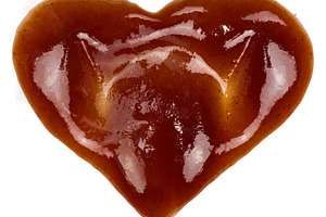 Spilled barbecue sauce in heart shape on isolated background, a Food & Drink Photo by ndanko