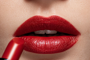 Woman applying bright red lipstick. Emphasizing beauty, fashion,, a Photo by Studio ANNA