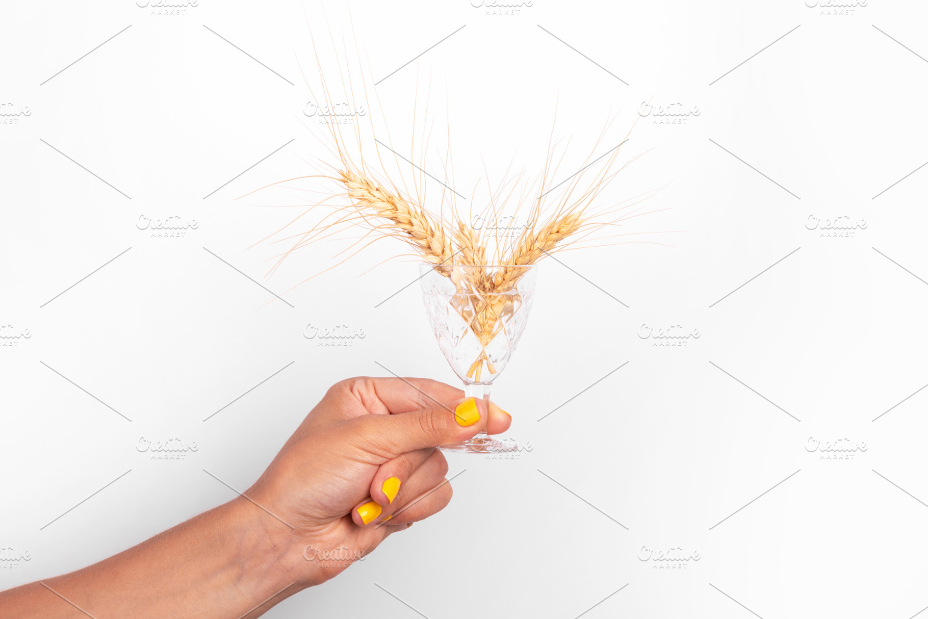 Close-up of a female hand with yellow nail polish holding a crys, a Food & Drink Photo by Ales Munt
