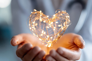 Glowing heart shape held in hands, an Abstract Photo by AlyaAnd