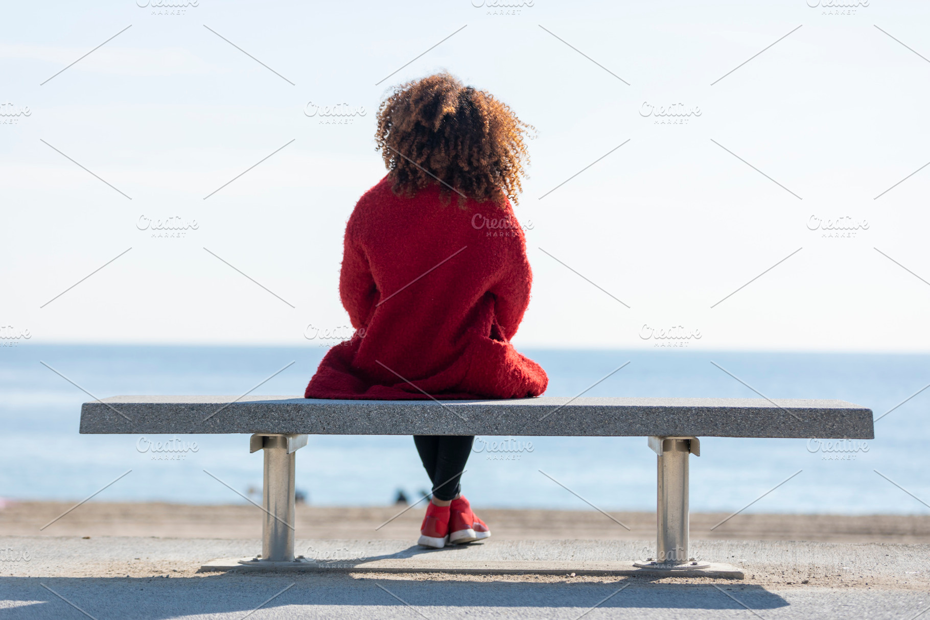 Rear view of a young curly woman wea featuring rear view, young, and woman, a Person Photo by 2Design
